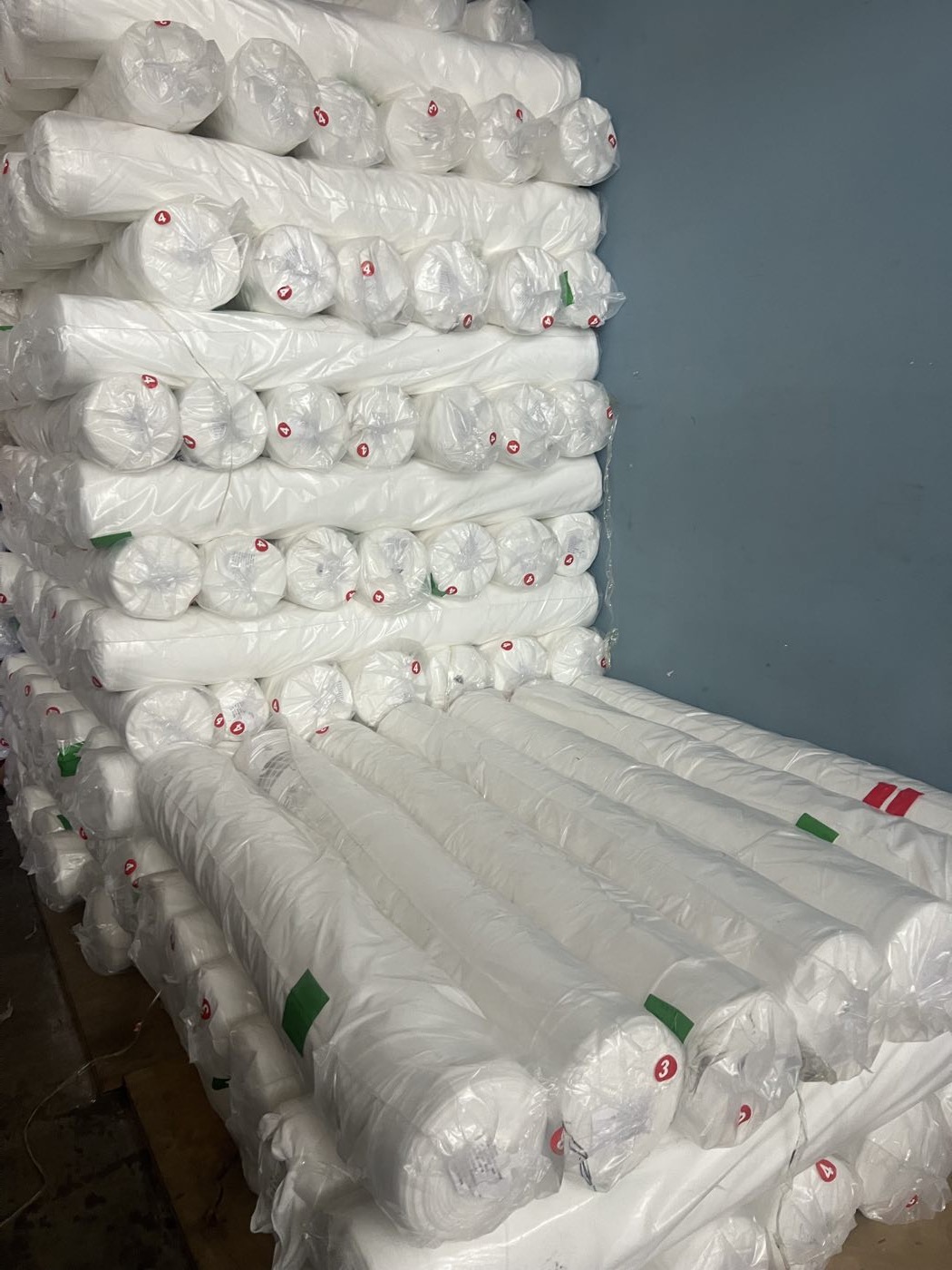 成垛存放的白色涤纶坯布卷